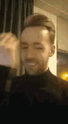 a close up of a man 's face with his eyes closed and a smile on his face .