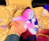 a woman with pink hair is hugging another woman with blue hair on a couch