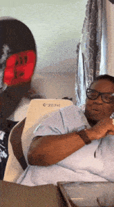 a woman wearing glasses is sitting in front of a white chair that says exim