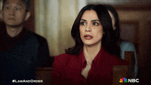 a woman in a red suit is sitting in a courtroom with nbc written on the bottom