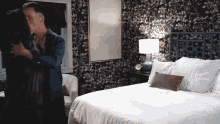 a man in a tuxedo kisses a woman in front of a bed