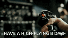 a person is holding a steering wheel with the words have a high-flying b day