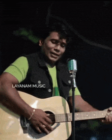 a man is singing into a microphone while playing a guitar and the word layanan music is on the bottom right