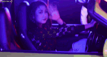 a woman in a sequined dress is sitting in the driver 's seat of a car .