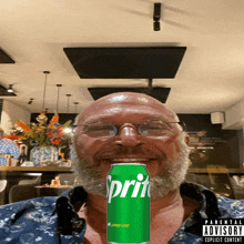 a man with a beard holds a can of sprite