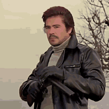 a man with a mustache is holding a gun