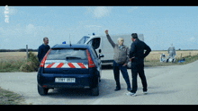 a man stands in front of a gendarmerie vehicle