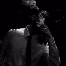 a man in a suit and tie smoking a cigarette