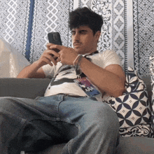 a man sits on a couch with a lanyard that says aaa on it