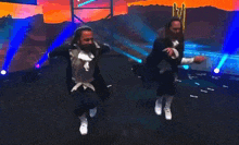 two men are dancing on a stage in front of a crowd .
