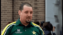 a man wearing a green and yellow icc cricket world cup shirt