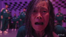 a woman is crying in front of a purple background with a netflix logo in the corner