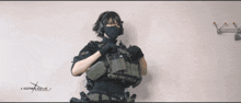 a person holding a gun in front of a sign that says ncsrwk.com.ua