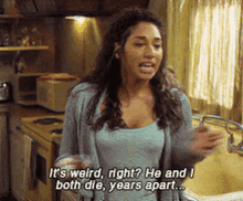 a woman in a kitchen says it 's weird right ? he and i both die , years apart ..