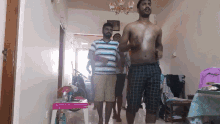a group of men are dancing in a living room with a barbie table in the background