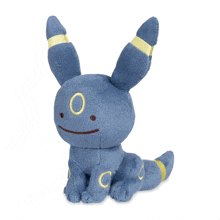 a blue stuffed animal with a yellow eye and the letter c on its tail