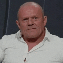 a man in a white shirt is making a funny face .