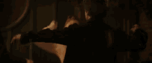 a woman is holding a man in her arms in a dark room and screaming .