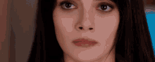 a close up of a woman 's face with a blue background .
