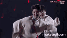 two men are hugging each other in front of a make a gif.com advertisement
