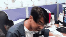 a man is sitting at a desk with chinese writing on his face