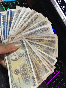 a hand is holding a bunch of money that says motinghin dong on it
