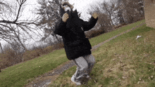 a person wearing a mask and a black jacket is dancing