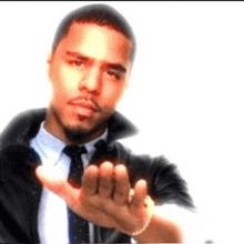 a man in a suit and tie is holding his hand out
