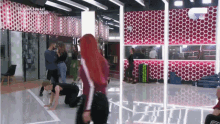 a group of people are dancing in a room with a red polka dot wall