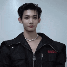 a young man wearing a black jacket that says finechic on the front