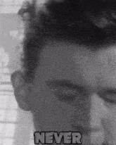 a man 's face is shown in a black and white photo with the word never below it