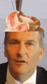 a close up of a man 's face with a cupcake on top