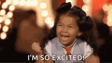 a little girl is smiling and saying i 'm so excited