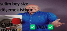 a bald man in a blue shirt is smiling in front of a cat wearing a red hat