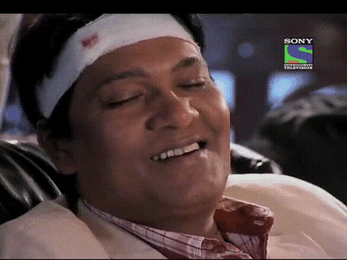 a man with a bandage on his head is smiling in front of a screen that says sony