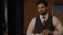 a man in a suit and tie holds a glass in his hand