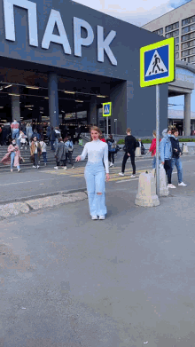 a woman stands in front of a building that says park on it