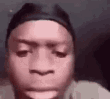 a close up of a person 's face with a headband on making a funny face .