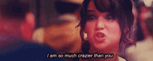 a woman is making a funny face and saying `` i am so much crazier than you ''