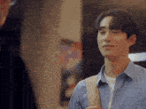 a man in a blue shirt is talking to another man in a room