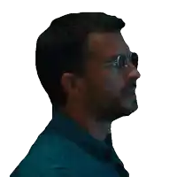 a man wearing glasses and a blue shirt is looking to the side