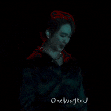 a man in a green shirt is standing in a dark room .