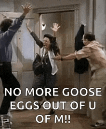 a man and a woman are jumping in the air in a room with a door .