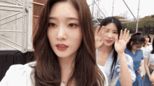 a group of women are standing next to each other and one of them is waving