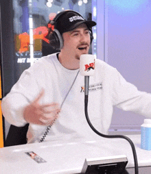 a man wearing headphones and a hat that says stella york is talking into a microphone
