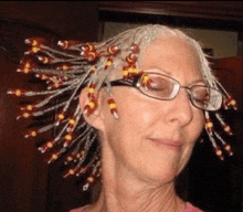 a woman wearing glasses and a bunch of beads on her hair