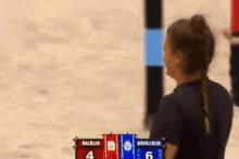 a woman is standing in front of a scoreboard that says 4 and 6