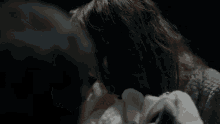 a woman is holding a baby in a dark room