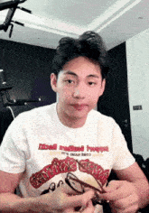 a man wearing a t-shirt that says ' disco ' on it holds a pair of glasses