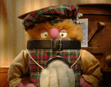 a stuffed animal wearing a kilt and a hat with the word sing on it